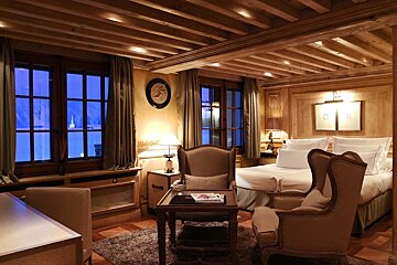 A bedroom with a clock on the wall above the bed