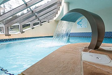 A swimming pool with a waterfall coming out of it