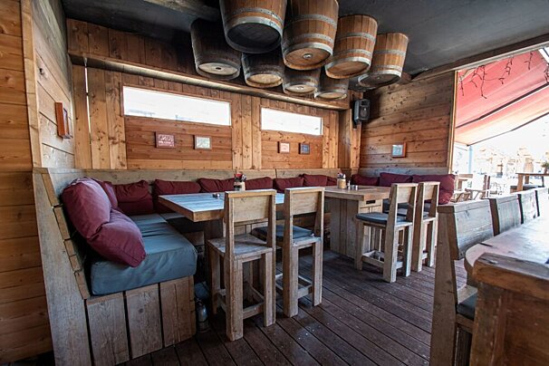 Wooden barrels hang from the ceiling of a restaurant