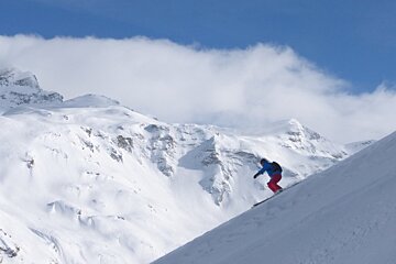 A person skiing down a snow covered mountain