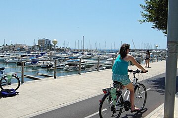 a girl on a bike near a marina in mallorca
