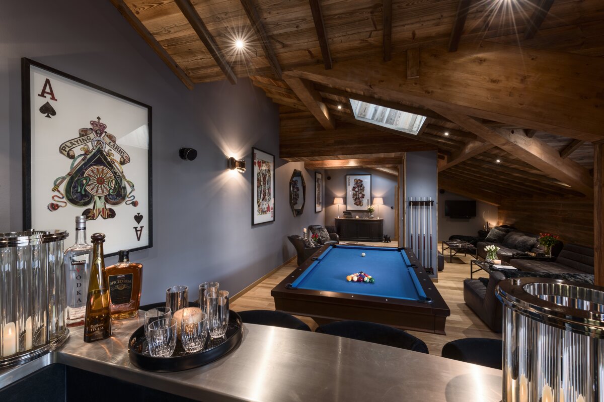 A bottle of vodka sits on a counter next to a pool table