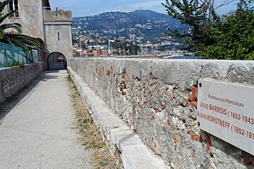 a stone wall above a beach in Nice