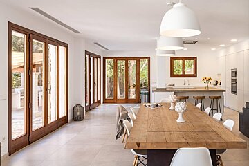 A dining room with a wooden table and white chairs