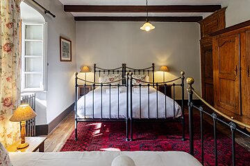 A bedroom with a bed and two lamps and a picture on the wall
