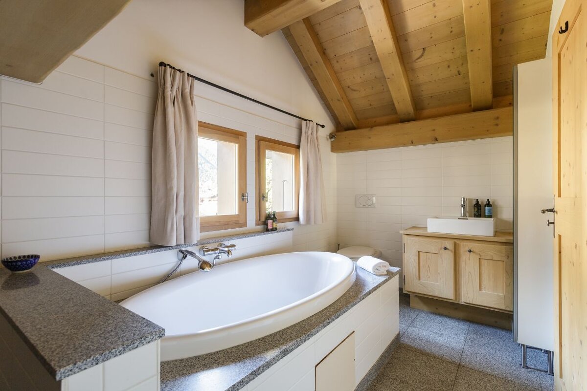 A bathtub in a bathroom with a wooden ceiling