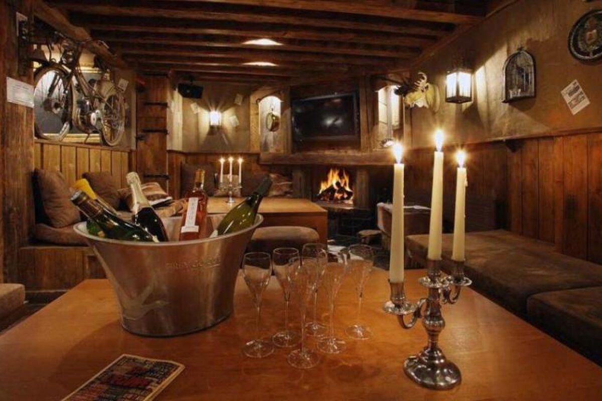 A bucket of champagne sits on a table next to candles