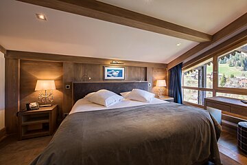 A bedroom with a large bed and a picture on the wall