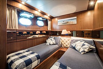 A bedroom with two beds and a painting on the wall