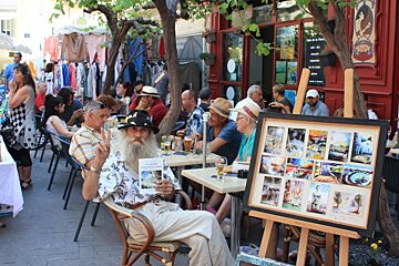 a man with a beard selling pictures in the market