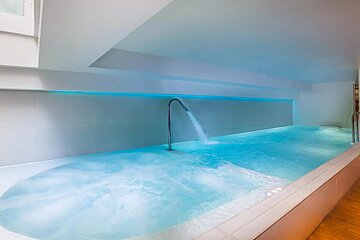 A swimming pool with blue water and a faucet coming out of it