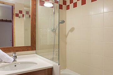 A bathroom with a sink a mirror and a shower