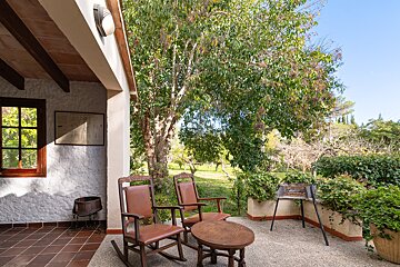 Two rocking chairs sit on a patio next to a table
