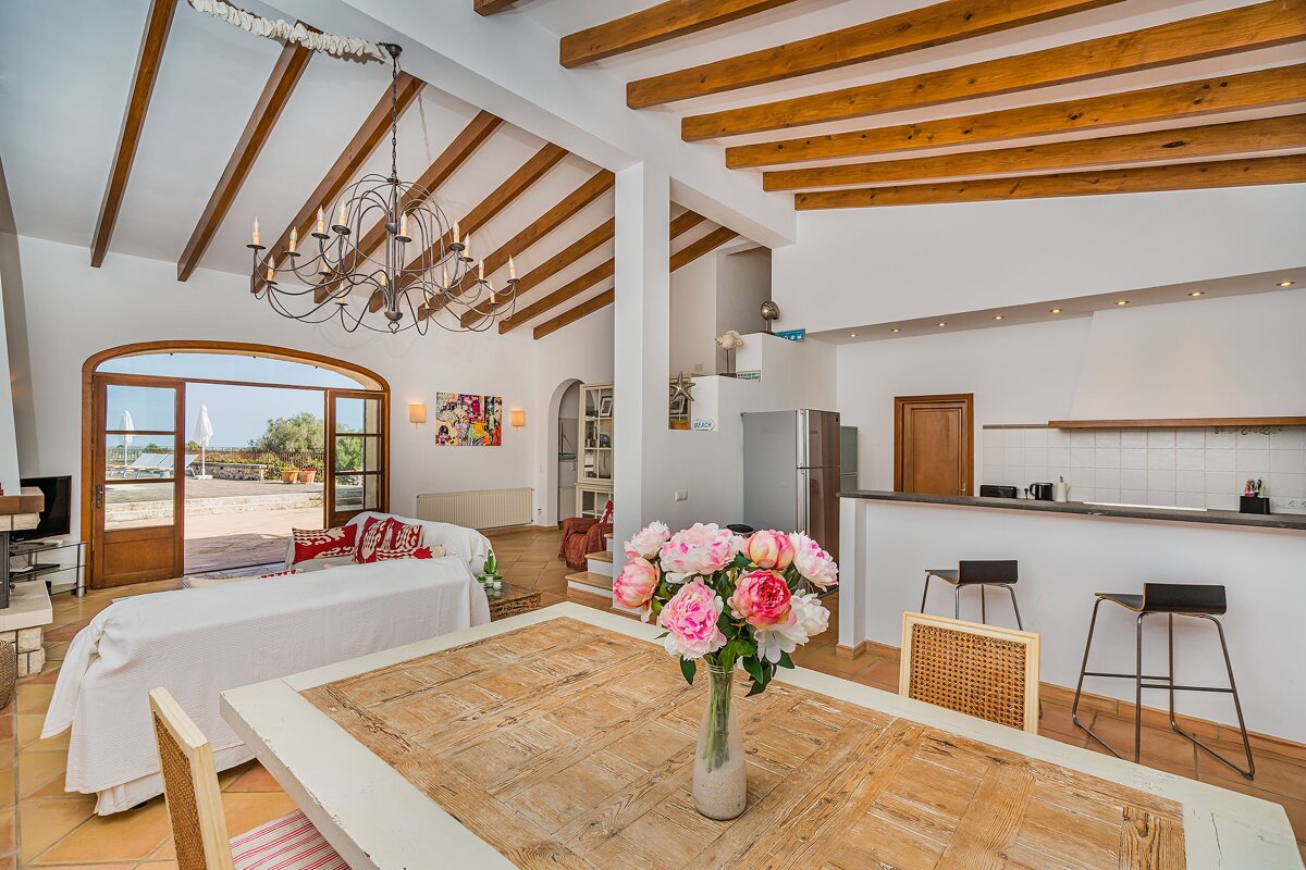 A vase of pink flowers sits on a wooden table in a living room