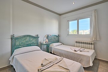 A bedroom with two twin beds and a window