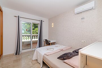 A bedroom with a sliding glass door leading to a balcony