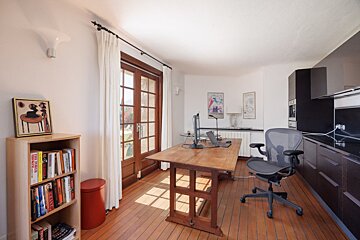 A room with a desk and a chair and a bookshelf with a book titled marvel comics