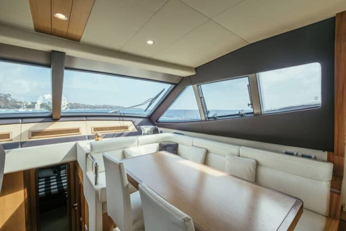 A dining room on a yacht with a table and chairs