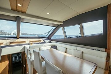A dining room on a yacht with a table and chairs