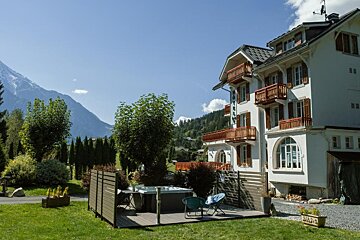 A large white house with a hot tub in front of it