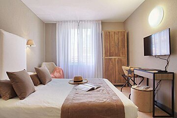 A hotel room with a large bed and a flat screen tv