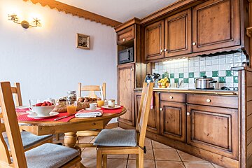 A kitchen with a table and chairs and a microwave