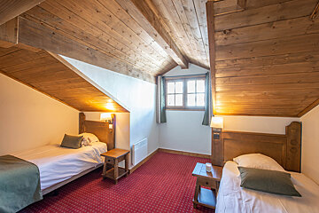 A bedroom with two beds and a window