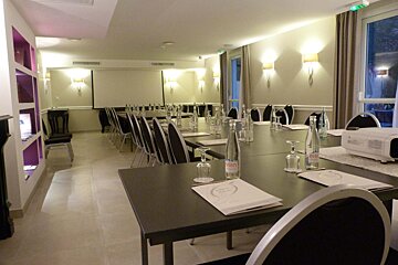 A bottle of evian water sits on a table in a conference room