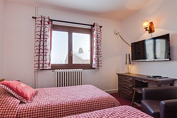A bedroom with two beds and a flat screen tv