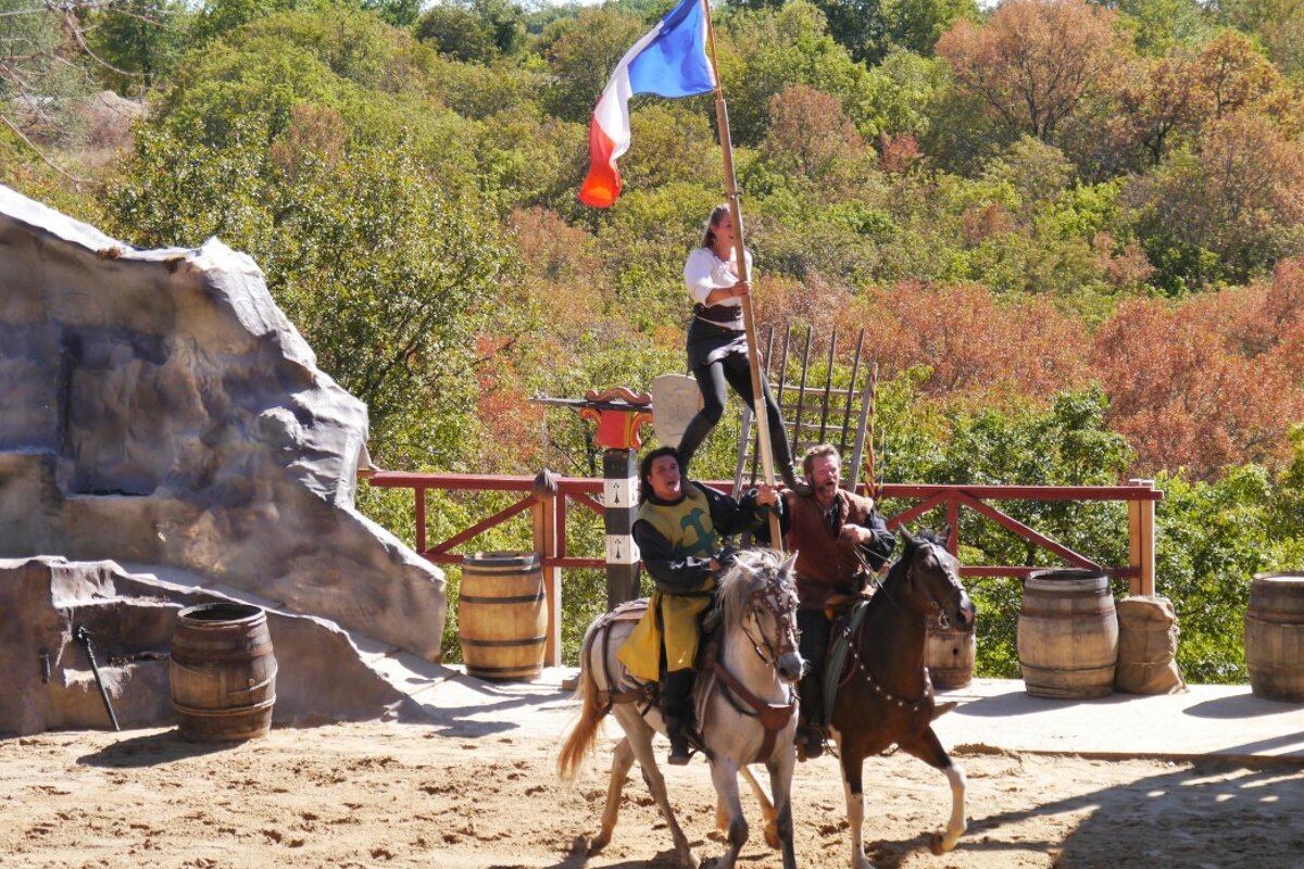 woman on men's shoulders on horseback at rocamadour