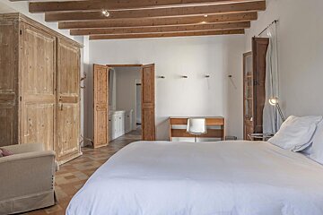 A bedroom with a large bed and a desk