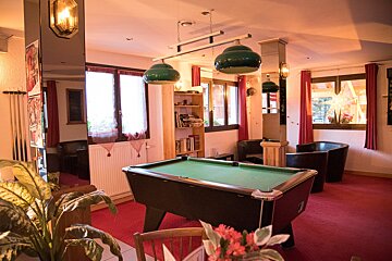 A pool table is in the middle of a room