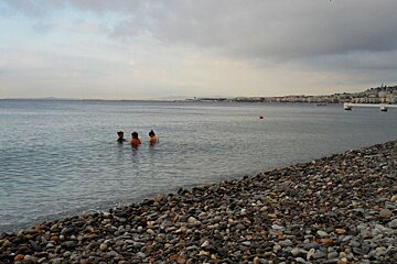 three people in the sea on a beach in Nice