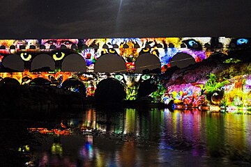 a roman ruin lit up with illuminations at night