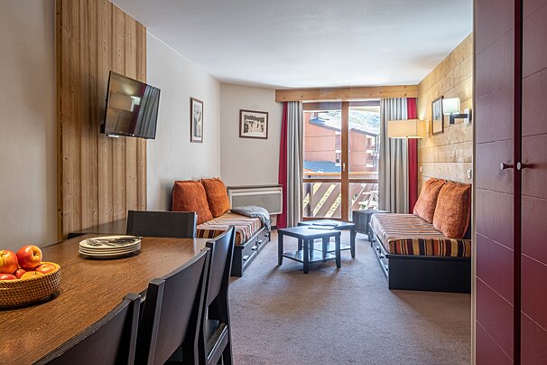 A living room with a couch a table and a television