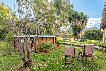 A garden with a wooden pool and chairs