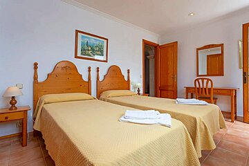 A bedroom with two beds a desk and a mirror