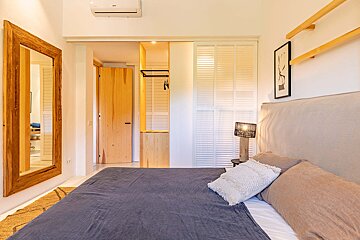 A bedroom with a large mirror on the wall