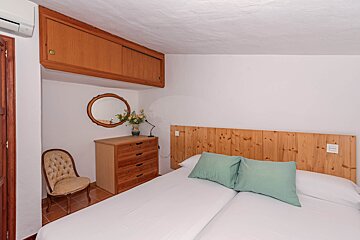 A bedroom with two beds a dresser and a mirror