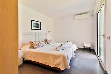 A bedroom with two beds and a picture on the wall