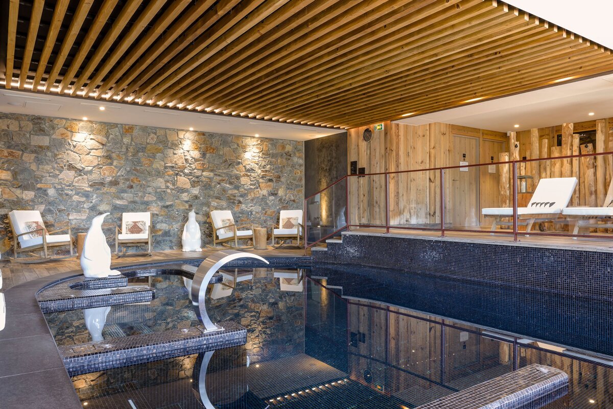 A large indoor swimming pool with a wooden ceiling