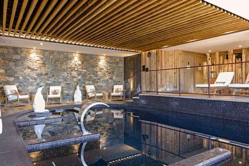 A large indoor swimming pool with a wooden ceiling