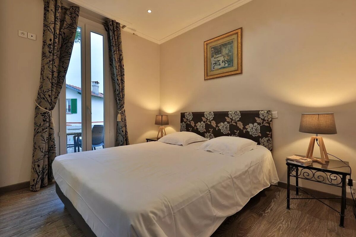 A bedroom with a large bed and two lamps