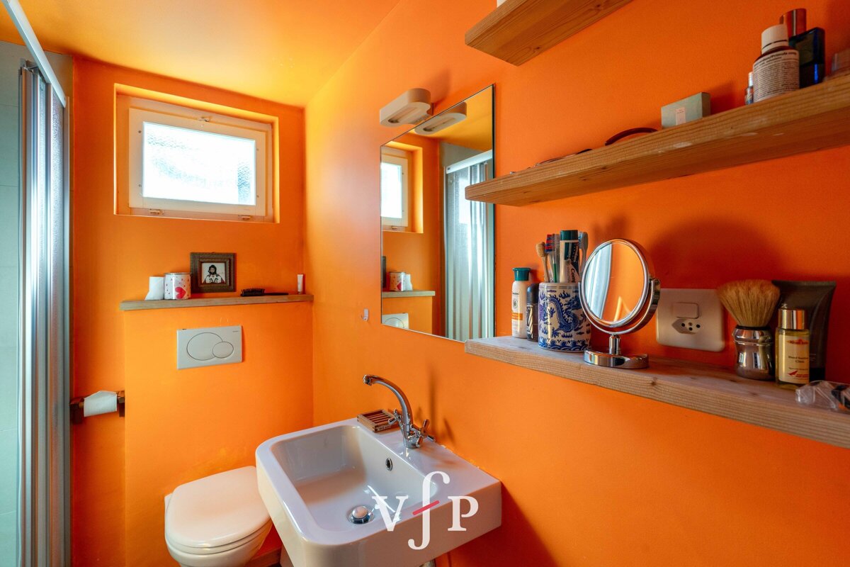 A bathroom with orange walls and a sink that says vjp