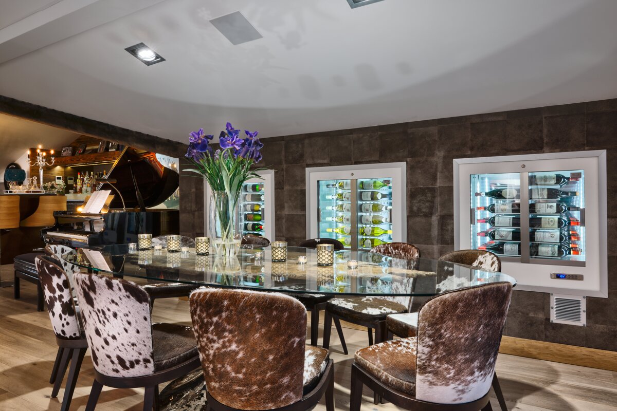 A dining room with a table and chairs and a piano