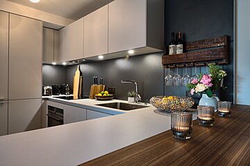 A kitchen counter with a bowl of lemons and candles on it