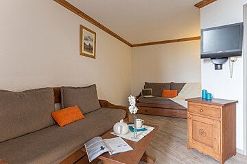 A living room with a couch a coffee table and a television