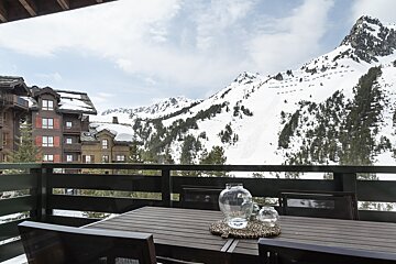 A balcony with a view of a snowy mountain