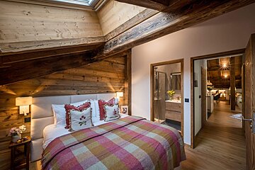 A bedroom with a king size bed and wooden walls