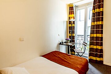 A hotel room with a small table and chair